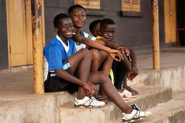 smiling children sitting on the street